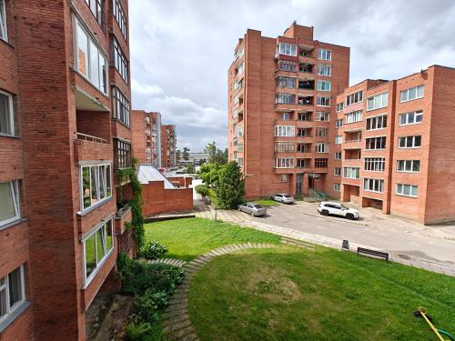 an apartment building with a grassy yard in a city at Holiday Ap in Visaginas