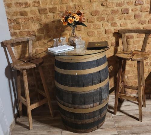 a wine barrel with a table and two chairs at Pousada Solar Azul in Miguel Pereira