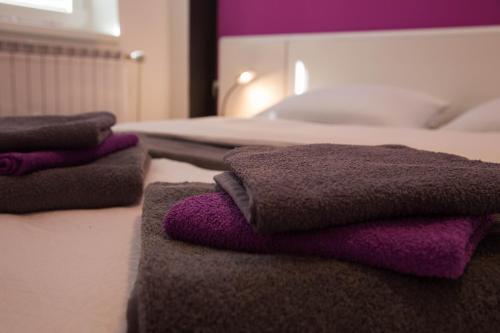 une pile de serviettes assises au-dessus d'un lit dans l'établissement Apartment Andolsek, à Bohinj