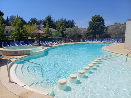 une grande piscine avec des chaises et des chaises bleues dans l'établissement Ardèche Horizon, Appartement climatisé avec Terrasse, Piscine et Parking, à Vallon-Pont-dʼArc