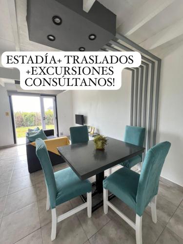 a dining room with a table and blue chairs at Casa YASA con parque privado y parrilla in El Calafate