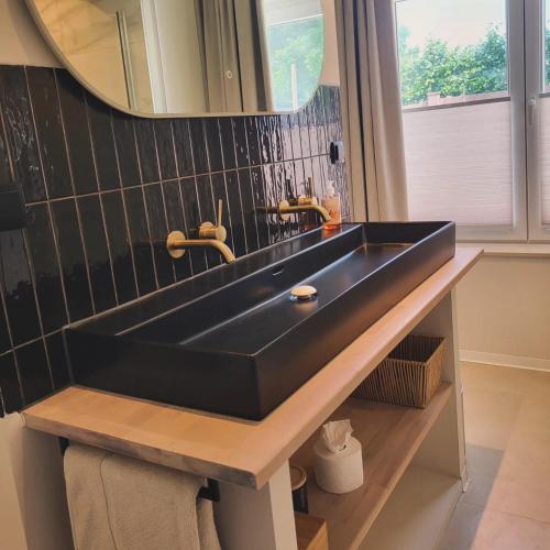 a black sink in a bathroom with a mirror at B&B Ut Zuuje in Valkenburg