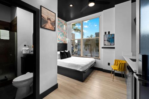 a small bedroom with a bed and a window at The Neon Elm Hotel in San Diego