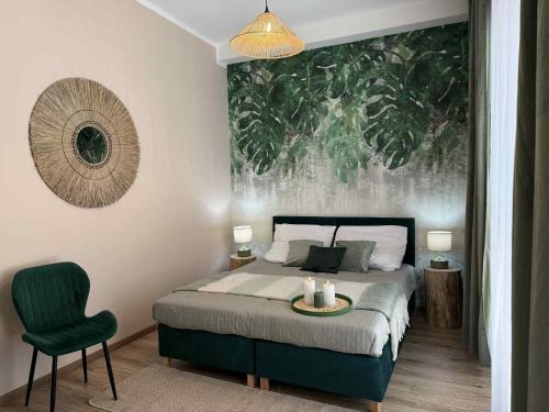 a bedroom with a bed and a green chair at Leśna Przystań in Pojezierze