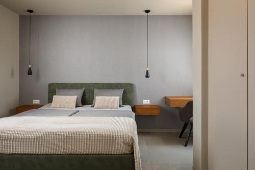 a bedroom with a green bed and a desk at Maneo Lux in Poreč