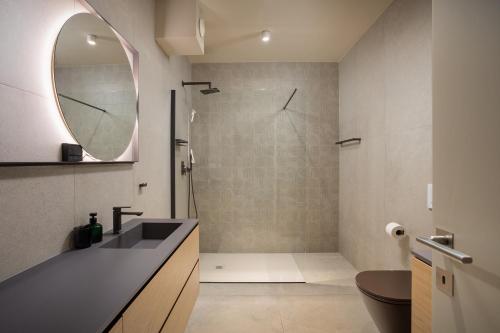 a bathroom with a shower and a sink and a mirror at Maneo Lux in Poreč