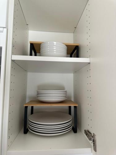 a cupboard filled with white plates and bowls at Motel Le Refuge in Sherbrooke