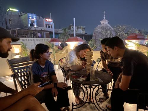 a group of people sitting around a table on a patio at The Commune Banaras in Varanasi