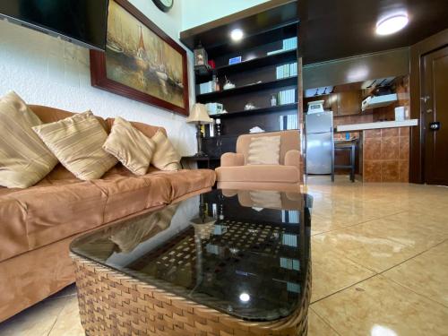 een woonkamer met een bank en een aquarium bij Mexican Style Top Floor in Cancun