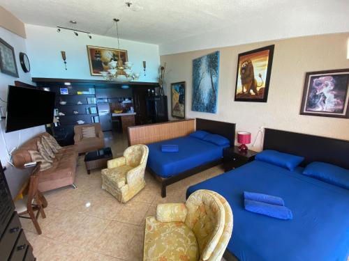 een woonkamer met een blauwe bank en een woonkamer met een bank bij Mexican Style Top Floor in Cancun