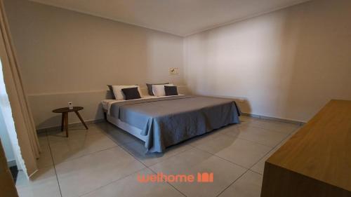 a bedroom with a bed and a table in it at Apartamento em Delfinopolis perto das Cachoeiras in Delfinópolis