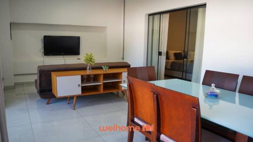 a living room with a dining table and a television at Apartamento em Delfinopolis perto das Cachoeiras in Delfinópolis