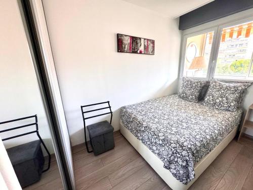 une petite chambre avec un lit et une fenêtre dans l'établissement Appartement Les Palmiers, à Juan-les-Pins