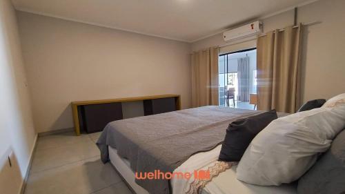 a bedroom with a large bed and a window at Apartamento em Delfinopolis perto das Cachoeiras in Delfinópolis