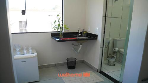 a bathroom with a sink and a toilet at Apartamento em Delfinopolis perto das Cachoeiras in Delfinópolis