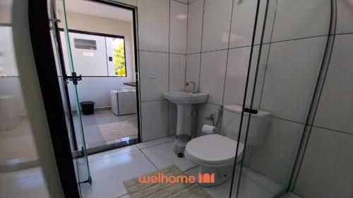 a bathroom with a toilet and a glass shower at Apartamento em Delfinopolis perto das Cachoeiras in Delfinópolis
