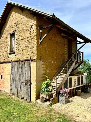 a brick building with stairs and potted plants on it at La Nyvolette in Avressieux