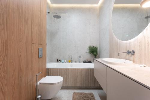 a bathroom with a toilet and a tub and a sink at Leśne spa przy Sopocie in Gdynia