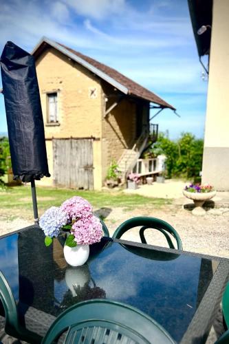a table with a vase of flowers on top of it at La Nyvolette in Avressieux
