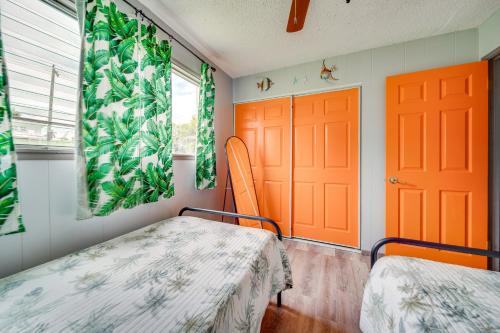 a room with two beds and two orange doors at Walk to Dtwn Hilo Island Escape with Pool! in Hilo