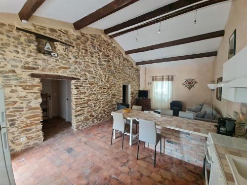 a kitchen and living room with a stone wall at Chambre d'hote Gîte Le Tilleul in Le Martinet
