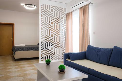 a living room with a blue couch and a table at Apartment with Pool "Sunset Cove" in Neum