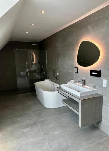 a large bathroom with a tub and a sink at Central Hotel in Flensburg