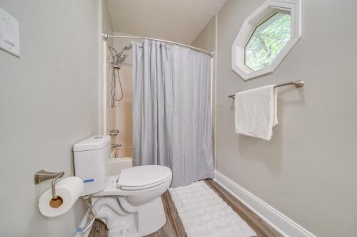 a white bathroom with a toilet and a shower at Walk to Mellwood Art Center Home with Private Deck! in Louisville