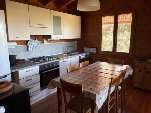 une cuisine avec une table en bois et une table et des chaises dans l'établissement Chalet Maria, à Bonifacio