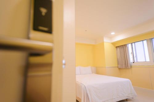 a small room with a bed and a window at KIWI-Taichung Station Branch 1 in Taichung