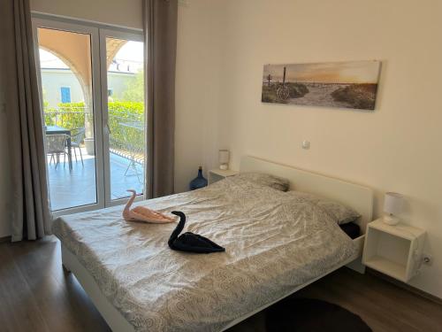 a bedroom with a bed with a swan on it at Natasa apartments Krk in Vrh
