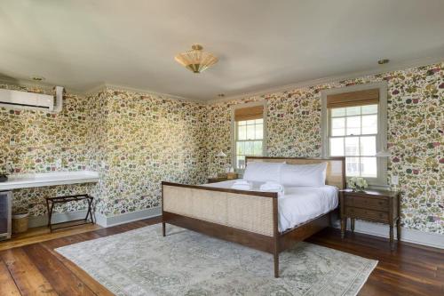 een slaapkamer met een bed en bloemenbehang bij The Nicholas Veranda King Suite - Walk to King in Charleston