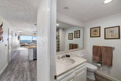 a bathroom with a sink and a toilet and a mirror at Sonoran Spa 2BR 2BA Sleeps 8 6th Floor- E607 in Campo del Medio