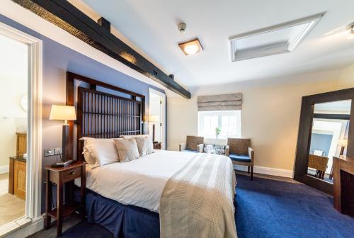 a hotel room with a large bed and a large window at The White Hart Hotel in Welwyn