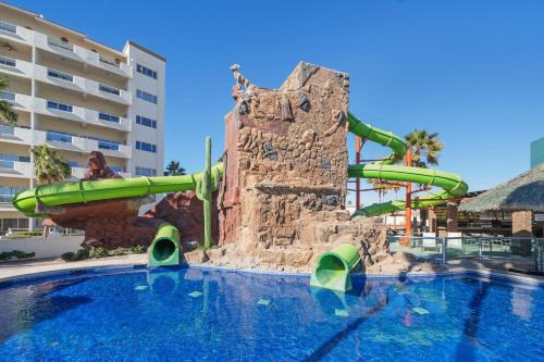 a water slide in a pool at a resort at Las Palmas 4BR 4BA Penthouse Ocean View 703 in Campo del Medio