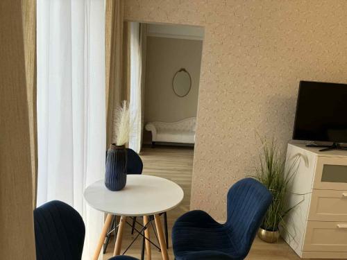 a living room with a table and blue chairs at Leśna Przystań in Przyjezierze