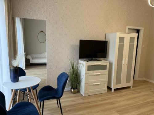 a living room with a television and a table and chairs at Leśna Przystań in Przyjezierze