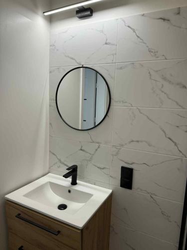 a bathroom with a sink and a mirror on a wall at Leśna Przystań in Pojezierze