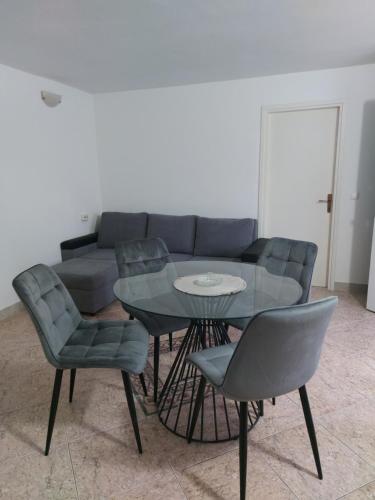 a dining room with a table and chairs and a couch at Apartments Vesna in Pag