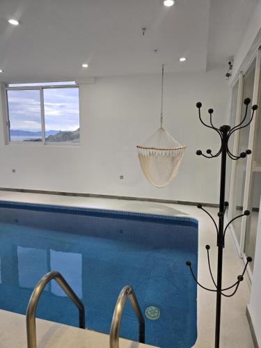 a swimming pool in a house with a hanging at Casa de Alara in Chapala