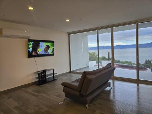 a living room with a couch and a flat screen tv at Casa de Alara in Chapala
