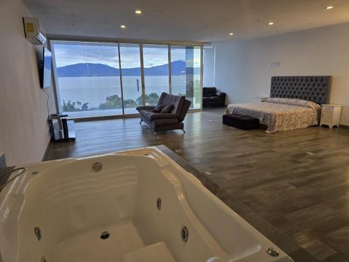 a large bathroom with a bath tub and a bedroom at Casa de Alara in Chapala