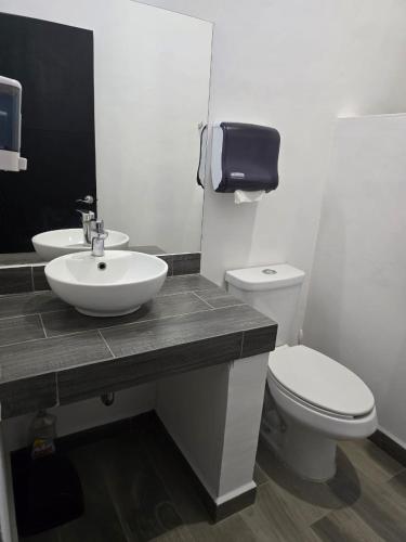 a bathroom with a white sink and a toilet at Casa de Alara in Chapala