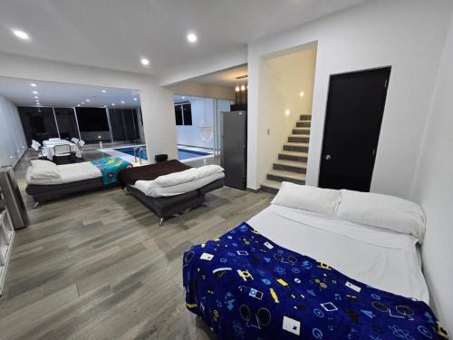 a large room with two beds and a staircase at Casa de Alara in Chapala