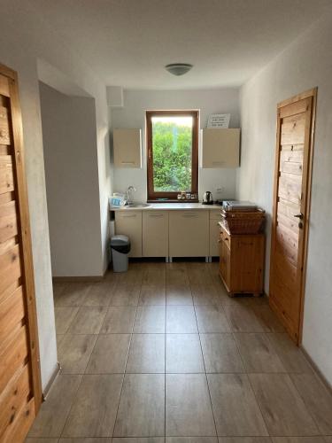 a kitchen with a sink and a window at Sielska Chatka in Sarbinowo