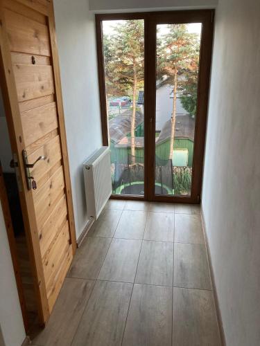 an empty hallway with a door and a window at Sielska Chatka in Sarbinowo