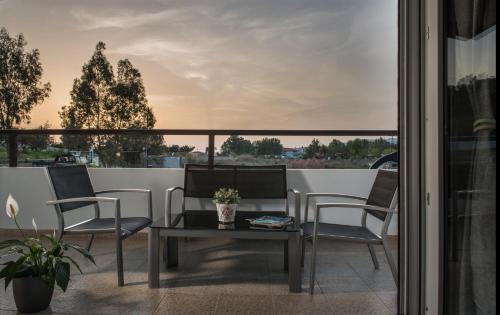 a patio with a table and chairs on a balcony at Caretta Village in Toroni