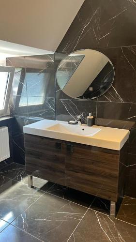 a bathroom with a sink and a mirror at Marlin City Apartment 2 in Bielefeld