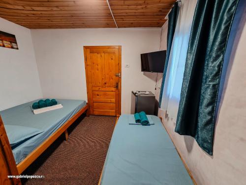 a small room with a bed and a wooden door at Summer Vibe Costinesti in Costinesti