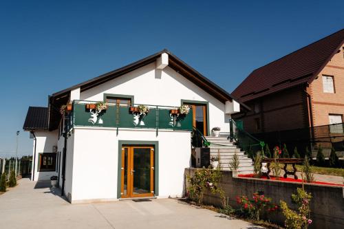 a white house with a balcony with dogs on it at Cerma Bucovina in Marginea